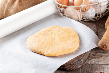 Raw dough on a cutting board on a rustic wooden table. Frozen dough
