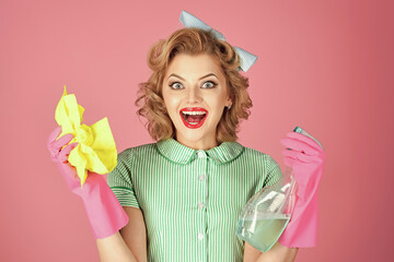 Excited housekeeper woman in uniform with clean spray, sponge. Pinup woman hold soup bottle,...