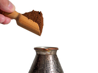 Man pours ground coffee into cezve.