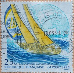 FRANCE - CIRCA 1993 : a postage stamp printed in France showing a sports sailor in high waves with people and sails set. Text: Sail around the world