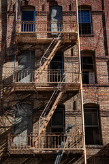 Fototapeta na wymiar Urban windows and external fire escapes