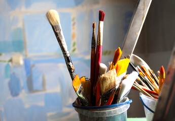 Art studio class painting brushes close up on blue abstract background. Brushes. Artist's workshop, artist's tools. Specially blurred.
