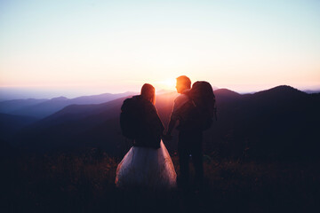 Two Lovers Holding Hands and Looking at the Sunset	