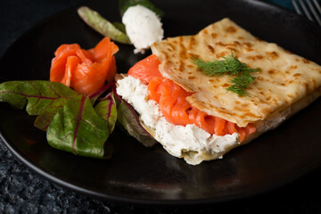 Traditional Russian thin pancakes with filling, red fish and cream cheese
