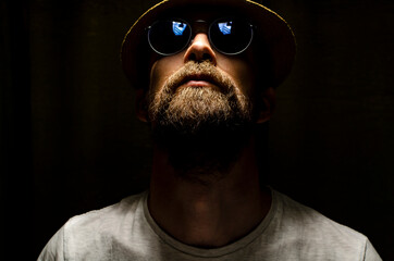 bearded man in glasses and a hat looks up. hipster portrait