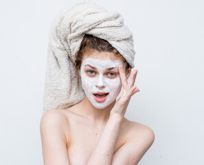 woman with bare shoulders with a towel on her head skin care facial mask