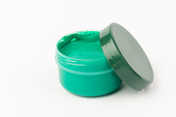Plastic jars with paint of green colors for children's creativity on white background. Paint...