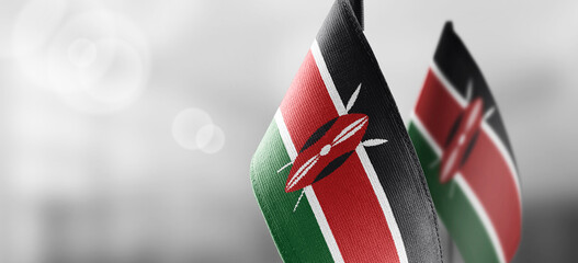 Small national flags of the Kenya on a light blurry background - obrazy, fototapety, plakaty