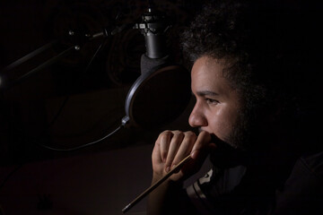 An content creator and internet influencer recording with a professional microphone for his video...