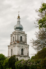 Fototapeta na wymiar Old bell tower on a gray sky background