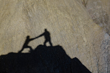 Shadow of two people on rock mountain