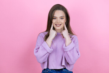 Young pretty woman with long hair standing over isolated pink background smiling confident showing and pointing with fingers teeth and mouth
