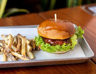 hamburguesas americanas con papas fritas en charolas de metal con mucho queso 
