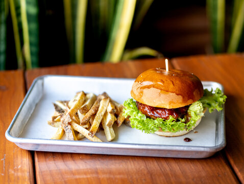 hamburguesas americanas con papas fritas en charolas de metal con mucho queso 
