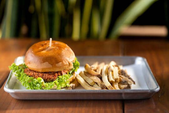 hamburguesas americanas con papas fritas en charolas de metal con mucho queso 
