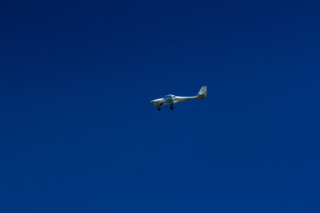 The plane flies in the blue sky