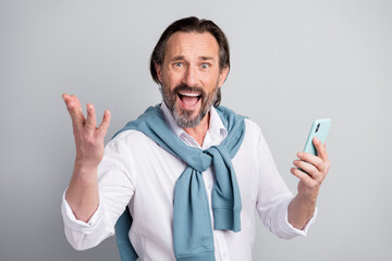 Portrait of astonished guy open mouth raise hand palm hanging sweater on shoulders isolated on grey...