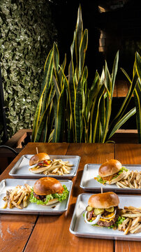hamburguesas americanas con papas fritas en charolas de metal con mucho queso 
