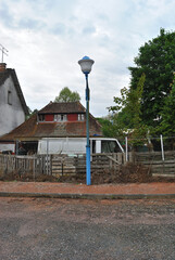 Old Building with Abandoned Van and Lamppost beside Car Park