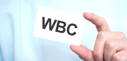 Man in blue sweatshirt holding a card with text WBC,business concept