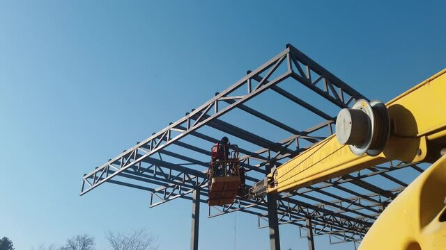 Steel worker operating cherry picker