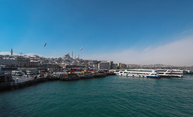Naklejka premium ISTANBUL, TURKEY - 17.Şubat .2021: the Golden Horn sea, passenger ferries, the famous Ottoman mosque Suleymaniye mosque dating from the 16th century tower and beyazıt.