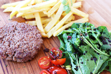 a delicious breakfast, Patty, French Fries, Tomatoes and vegetables.