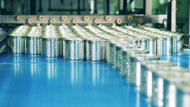 Sealed tin cans are piling up on the conveyor