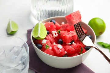 Delicious salad with watermelon, blueberries and cheese on white table, closeup