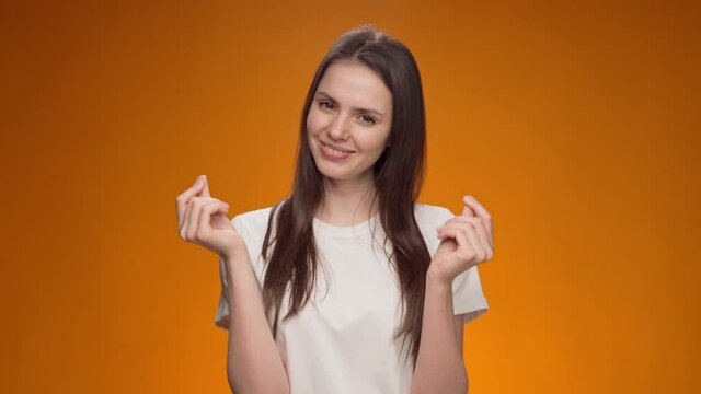 Young woman showing gesture of wasting money against yellow background, materialist, shopping concept