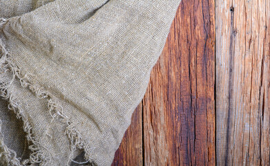 The texture of burlap on old sun-bleached boards. rustic style. Natural texture of aged boards and linen and with creases and shadows.