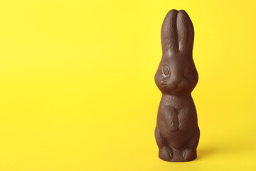 Fototapeta na wymiar Chocolate bunny on yellow background, space for text. Easter celebration