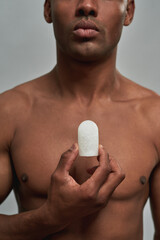 Crystal deodorant stone in a person hand