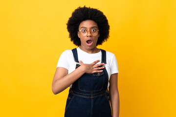 Young African American woman isolated on yellow background surprised and shocked while looking right