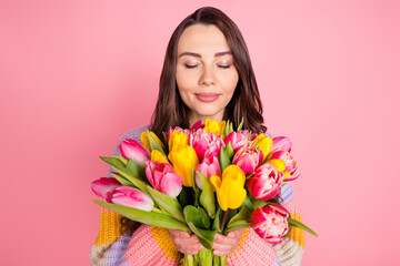 Portrait of attractive dreamy peaceful girl holding smelling bunch tulips event congrats isolated over pink pastel color background