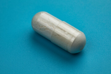 Medical capsule on blue background. Health care concept.