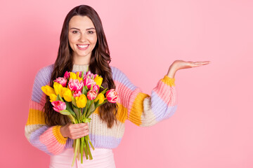 Portrait of pretty cheerful trendy girl holding tulips on palm copy empty space offer advert...