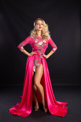 Beautiful blonde in a pink sexy dress on a black background.