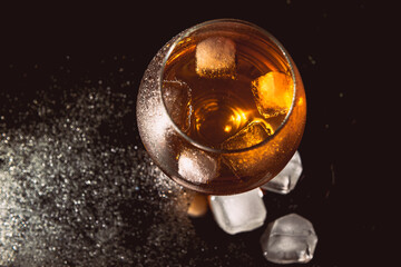 A glass of cognac on a dark background.