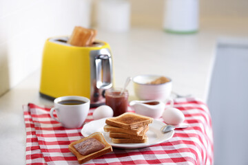 Fototapeta na wymiar Modern toaster and delicious breakfast on table in kitchen