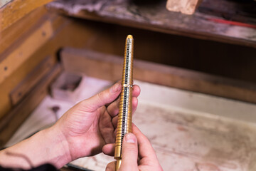 Male hands of a jeweler who measures the size of a ring using a ring gauge