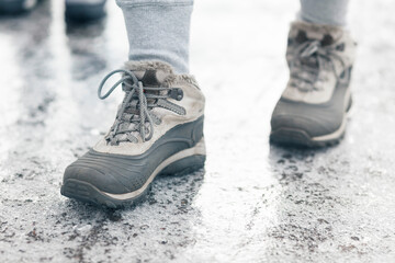 Winter shoes on the icy, frozen sidewalk. Dangerous weather.