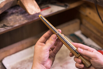 Male hands of a jeweler who measures the size of a ring using a ring gauge
