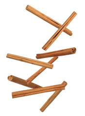 Aromatic cinnamon sticks falling on white background