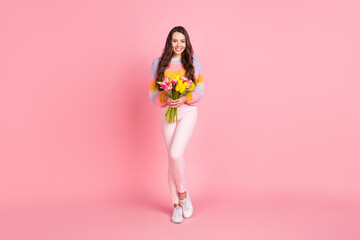 Fototapeta na wymiar Full length body size view of attractive cheerful thin girl holding bunch tulips event isolated over pink pastel color background