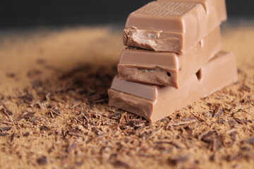 Three chocolate couscous lie on the cocoa on a black grey background with room for a copy of the chocolate brown chocolate table
