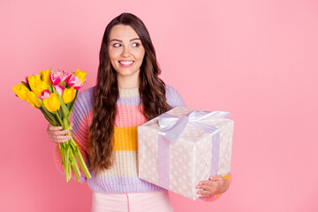 Obraz na płótnie Canvas Portrait of attractive cheerful girl holding in hands tulips giftbox looking aside copy space sale isolated over pink pastel color background
