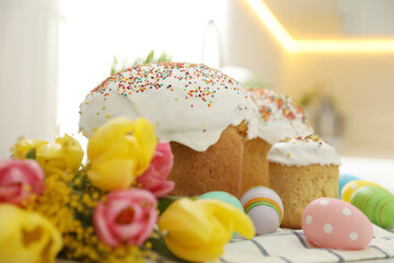 Traditional Easter cakes, flowers and dyed eggs on table, closeup