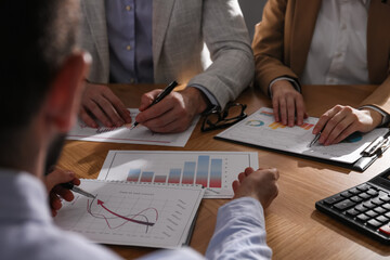 Business people working with charts and graphs at table in office, closeup. Investment analysis