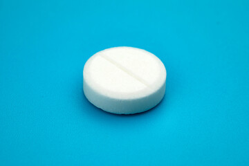 White round pill on blue background. Health care concept.